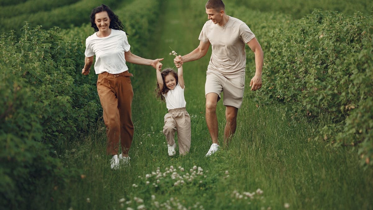 Joyful family enjoying a fun day outdoors in a green field, epitomizing togetherness and happiness.